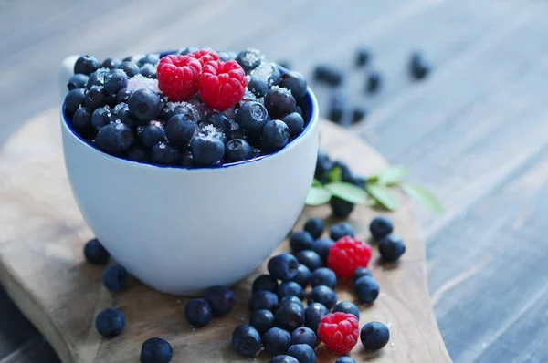Juicy berries of bilberry and raspberry in a cup — Stock Photo, Image