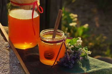 Bir cam kavanoz, peteğin ve melliferous çiçekler tatlım 