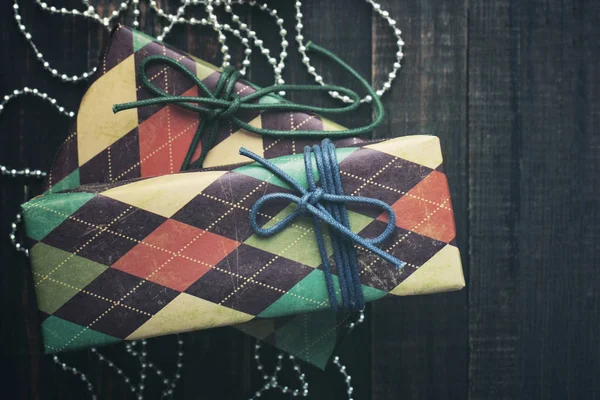 Christmas gifts. Festive boxes in colorful paper on a wooden background in vintage color — Stock Photo, Image