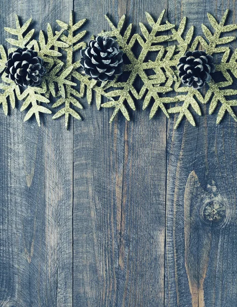 Fondo di legno di Natale con fiocchi di neve decorativi e coni del pino. — Foto Stock