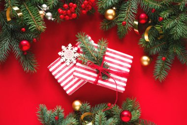 Firavun dalları, bayram süslemeleri ve hediye paketleri veya kırmızı arka planda sunum kutuları, metin için en üstteki manzara. Noel arkaplanı, Noel kartı.