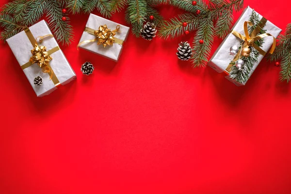 クリスマスの冬の背景 クリスマスカード 赤い背景の上のフェアブランチ 休日の装飾やギフトやプレゼントボックス テキストのためのスペース付きのトップビュー — ストック写真
