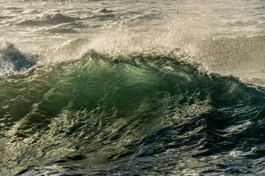 Güneş doğarken Güney Afrika 'daki Marina plajında çekilen bir dalganın detaylı çekimi..