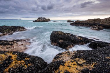Hermanus, Güney Afrika 'da fırtınalı, bulutlu bir öğleden sonra çekilmiş güzel bir deniz manzarası..
