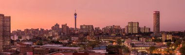 Johannesburg şehir siluetinin güzel ve dramatik bir fotoğrafı, gün batımından sonra altın bir akşamda çekildi..