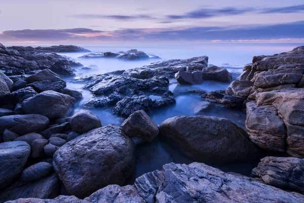 一张黎明前的照片 照片上是南非南部海岸的云雾冲刷在岩石上的景象 — 图库照片