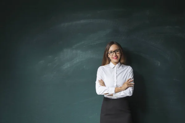 Young woman in front of blackboard — Stock Photo, Image