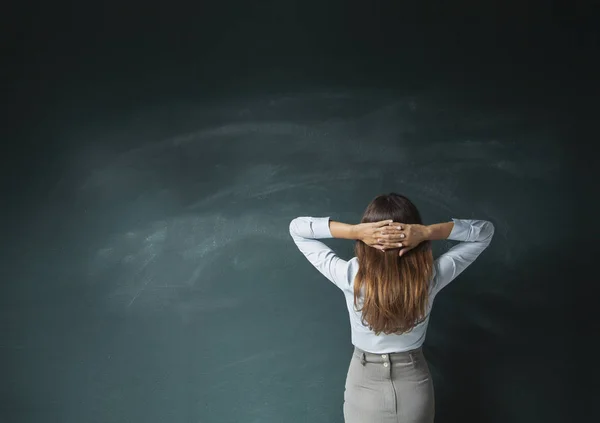 Zakenvrouw kijken leeg schoolbord — Stockfoto