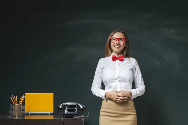 Young woman in front of blackboard — Stock Photo, Image