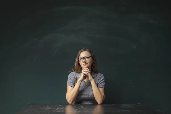 Pensativo jovem mulher no quadro de chalkboard fundo — Fotografia de Stock