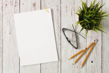 Beyaz masa üzerinde boş kağıt yığını olan bir model.