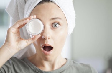 Genç bir kadın kayağına nemlendirici sürüyor.