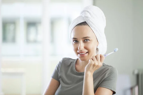 Retrato de una linda mujer sonriente sosteniendo un cepillo de dientes —  Fotos de Stock