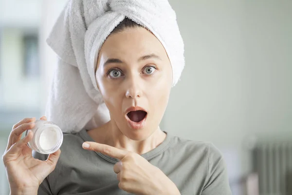 Young woman applying moisturizer to her ski — Stock Photo, Image