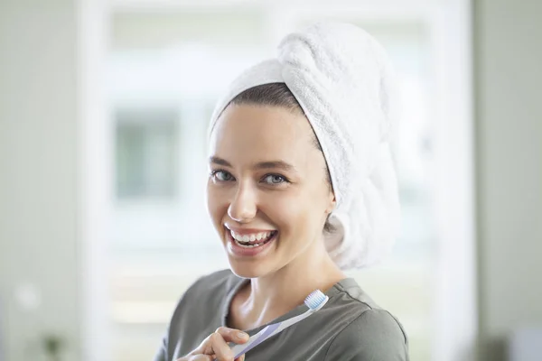 Retrato de una linda mujer sonriente sosteniendo un cepillo de dientes —  Fotos de Stock