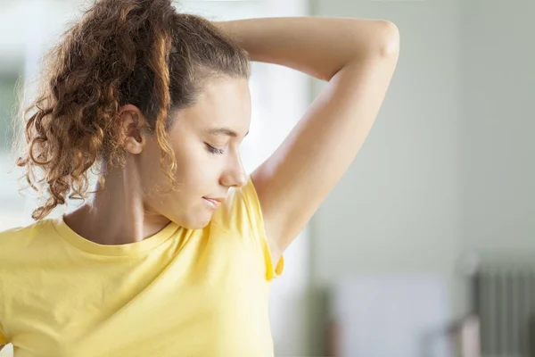 Young woman smelling her armpits — Stock Photo, Image