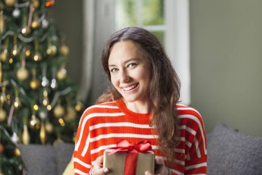 Elinde hediye kutusu olan genç bir kadın. 