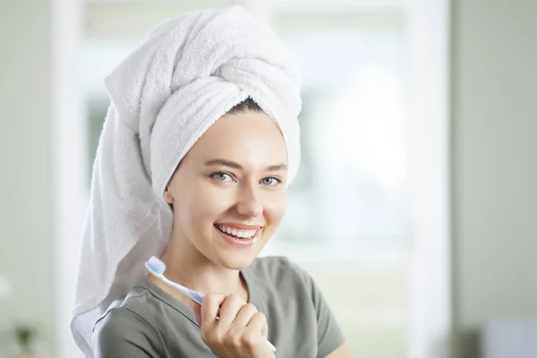 Portret van een lachende schattige vrouw met tandenborstel — Stockfoto