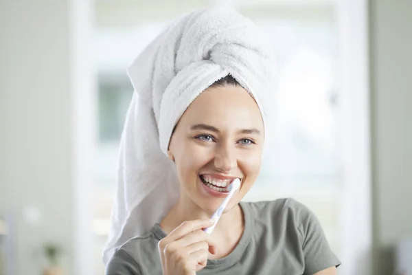 Mujer joven cepillándose los dientes. —  Fotos de Stock