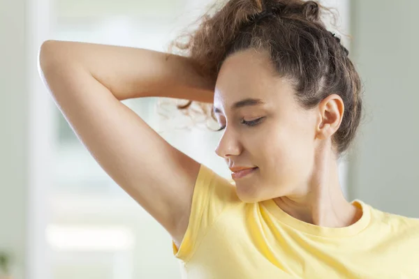 Mujer joven oliendo sus axilas — Foto de Stock