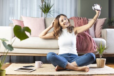 Kadın evde selfie çekiyor.