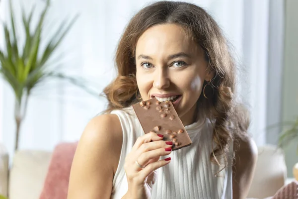 Mujer joven disfrutando de una barra de chocolate en hom —  Fotos de Stock