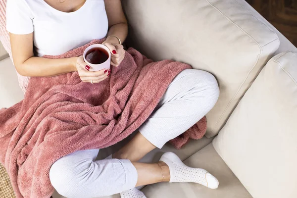 Молодая женщина пьет утренний чай на диване — стоковое фото
