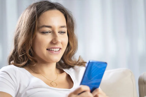 Jonge vrouw met behulp van telefoon thuis — Stockfoto