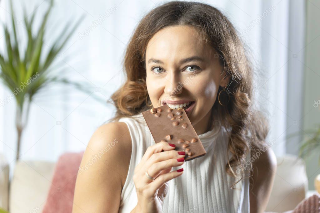 Young woman enjoying a chocolate bar at hom