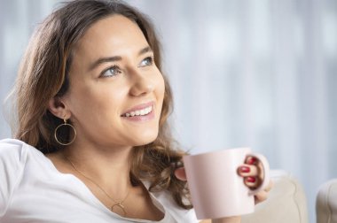 Genç bayan bir fincan kahve içiyor.