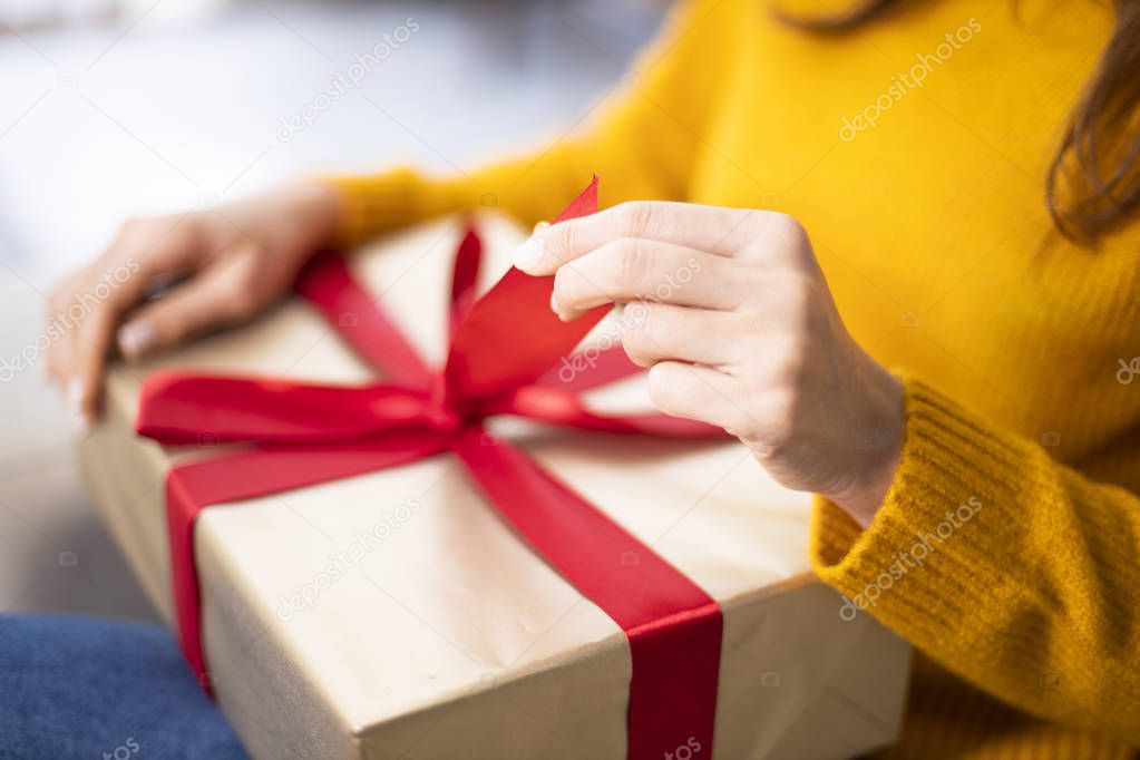 Woman opening gift box over living roo