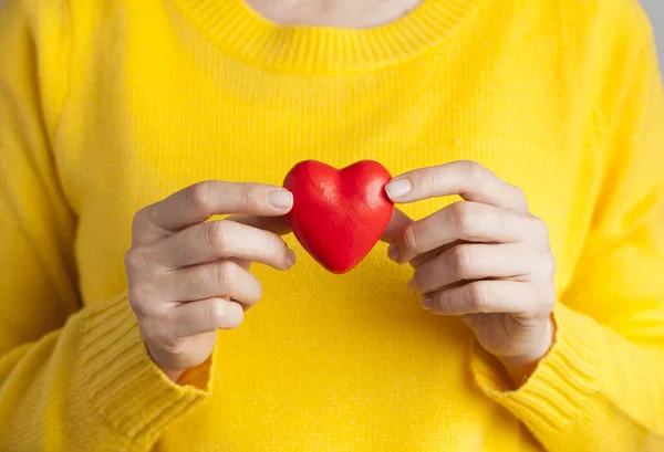 Ung kvinna med rött hjärta, sjukförsäkring, donation, kärlek — Stockfoto