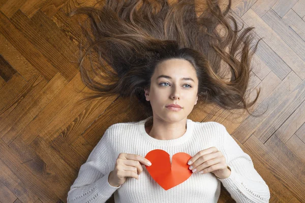 Woman tearing up a red paper heart — 스톡 사진