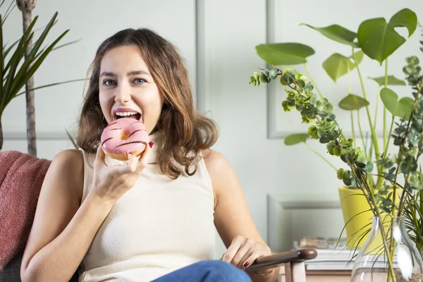 Mladá žena jíst růžové čokoládové lupínky — Stock fotografie