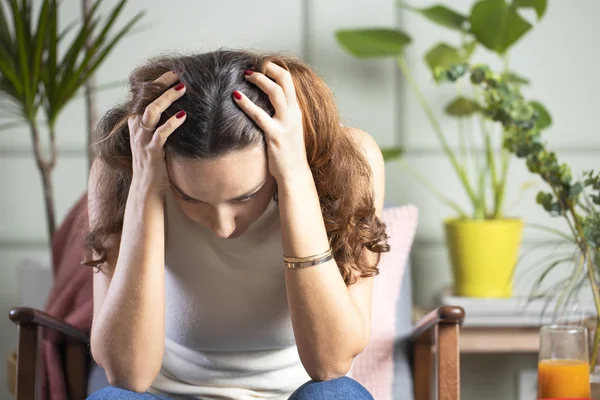 Депрессивная молодая женщина на диване в доме — стоковое фото