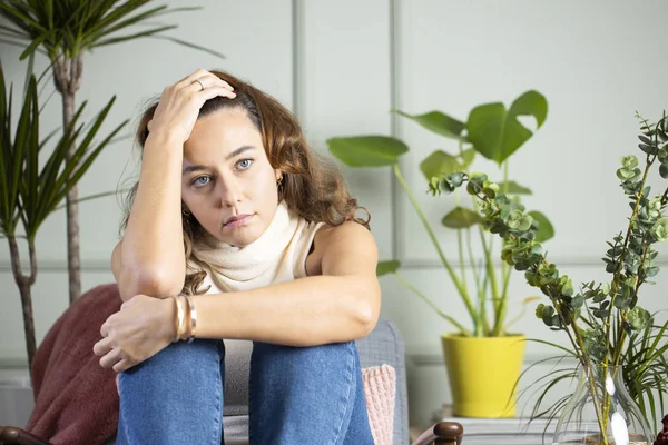 Депрессивная молодая женщина на диване в доме — стоковое фото