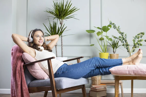 Ung kvinna lyssnar på musik hemma — Stockfoto