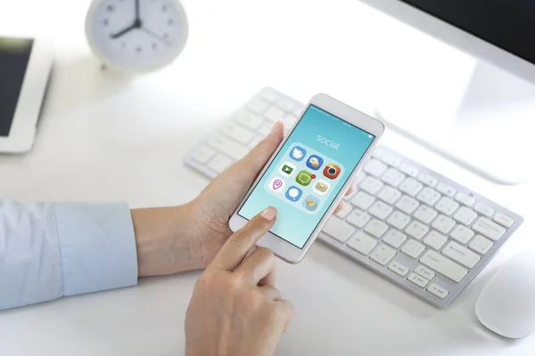 スマートフォンでソーシャルメディアアプリケーションを見ている女性は ユニークなアイコンを設計 — ストック写真