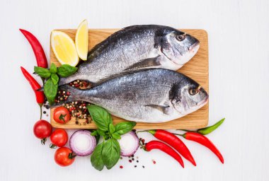 Ahşap kesme tahtası üzerinde taze çiğ dorado balık. Üstten Görünüm