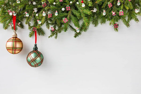 Weihnachtlicher Hintergrund. Tannenbaum mit Dekoration auf weißem Holzbrett Hintergrund mit Kopierraum — Stockfoto