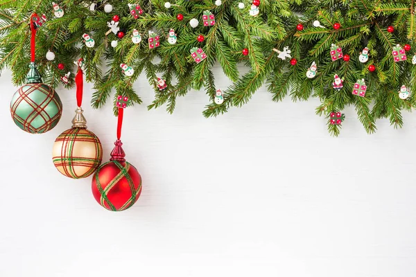 Weihnachtlicher Hintergrund. Tannenzweig mit Dekoration auf weißem Holzbrett Hintergrund — Stockfoto