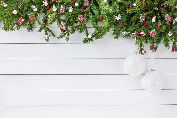Weihnachtlicher Hintergrund. Tannenbaum mit Dekoration auf weißem Holzbretthintergrund. Kopierraum — Stockfoto