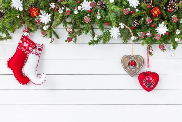 Weihnachtlicher Hintergrund. Tannenzweige, Weihnachtssocken auf weißem Holzbrett Hintergrund. — Stockfoto