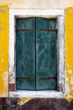 Eski pencere ile sarı duvarda yeşil kapamak. İtalya, Venedik, Burano