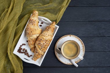 Taze kruvasan ve kahve siyah masada. Üstten Görünüm, kopya alanı.