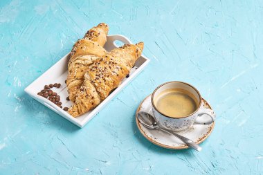 Taze kepekli croissants ve kahve mavi masada. Kopya alanı