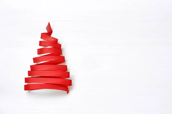Vánoční strom vyrobený z červenou stuhou na bílém pozadí. Kopírovat prostor — Stock fotografie