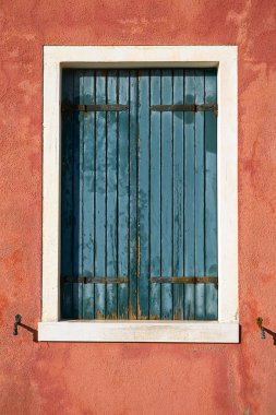 Pencere kapalı yeşil nokta kırmızı duvar ile. İtalya, Venedik, Burano Adası.