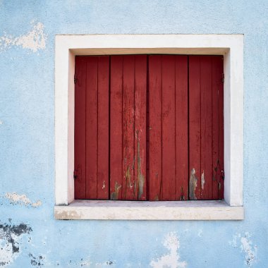 Mavi duvar kapalı kırmızı nokta ile pencere. İtalya, Venedik, Burano Adası.