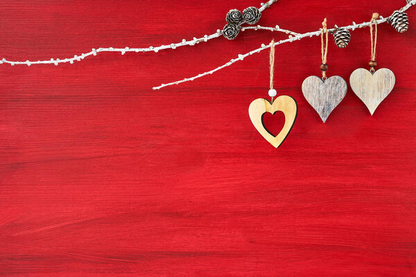 Red background with three wooden hearts. Valentines Day background. Copy space , top view